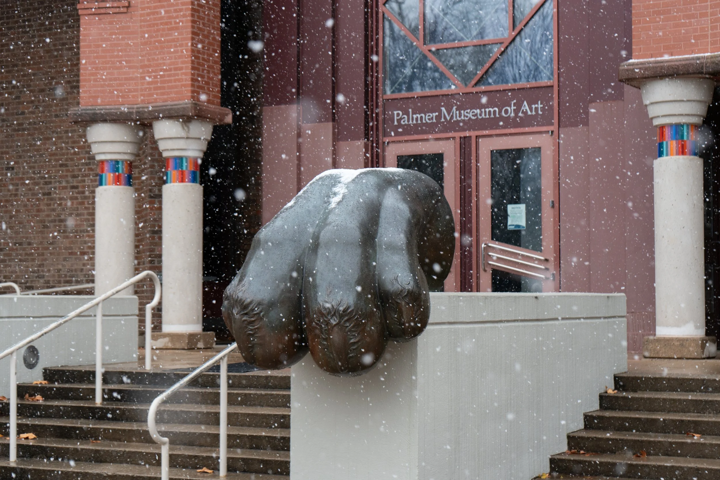 Snow falls on the lion paw in front of the Palmer Museum of Art on Friday, Nov. 22, 2024 in University Park, Pa.