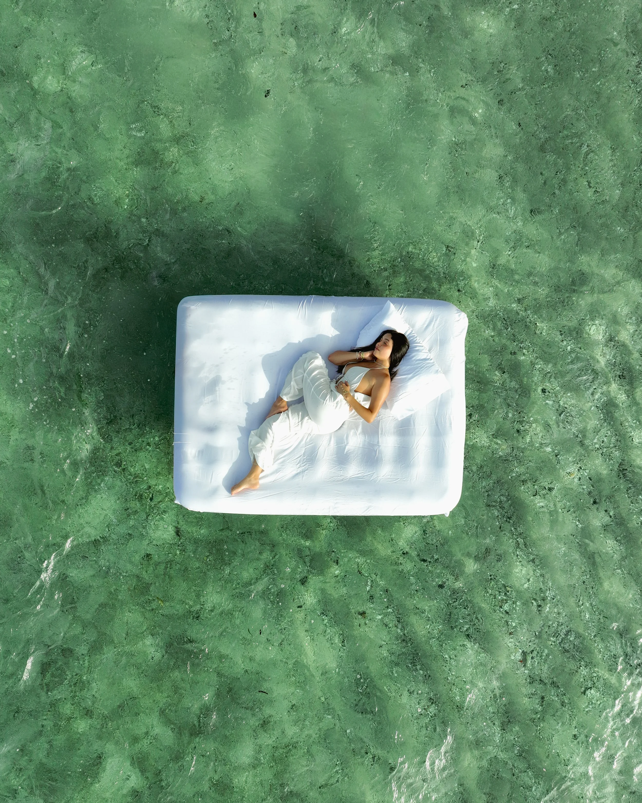 Modelo descansando en una cama blanca sobre la laguna. Vol 3 de Sol de Fondo. Proyecto de Ketzy Nachelle.