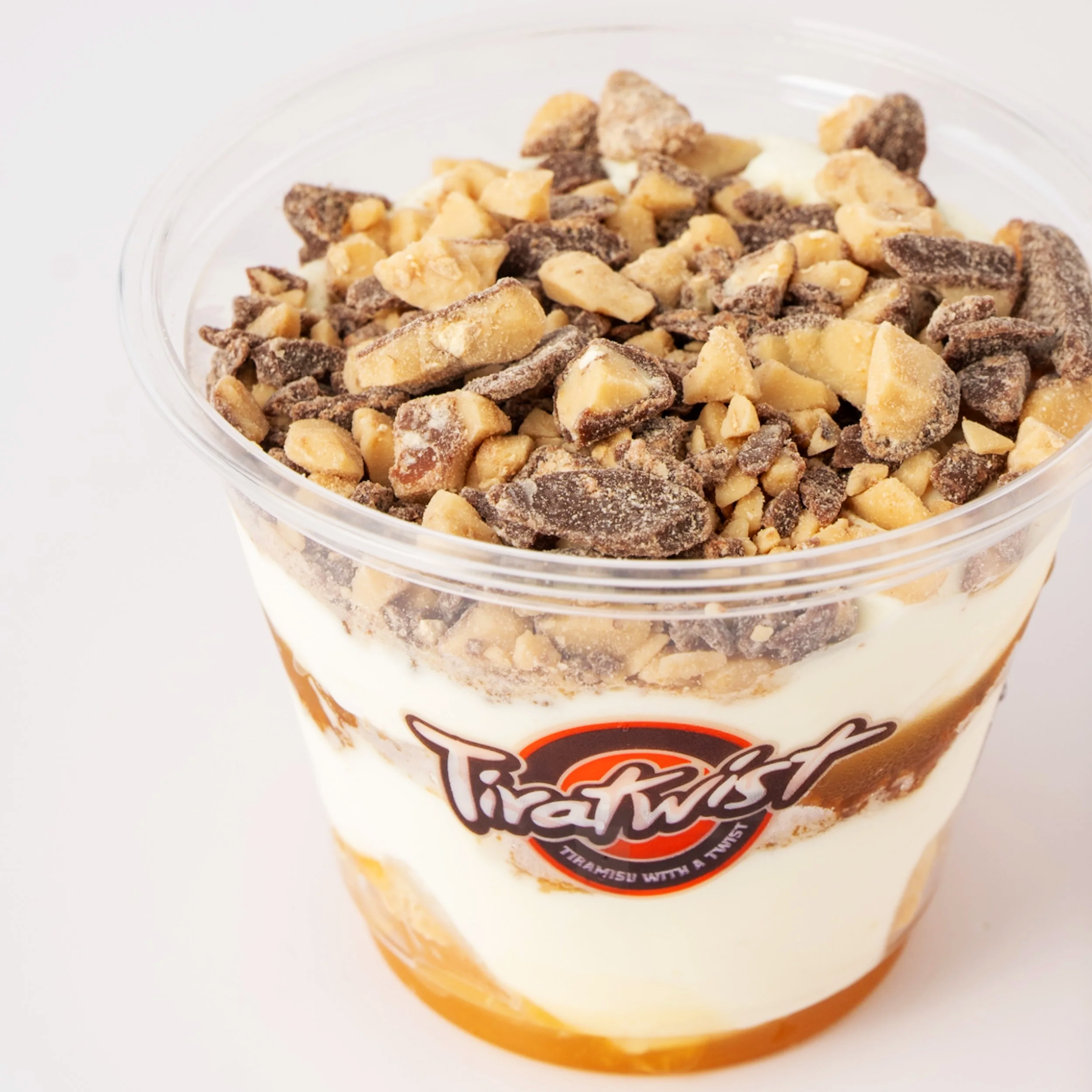 Layered dessert in a glass jar with a cookie crust base, creamy middle layers with chocolate chunks, topped with crushed chocolate cookies.