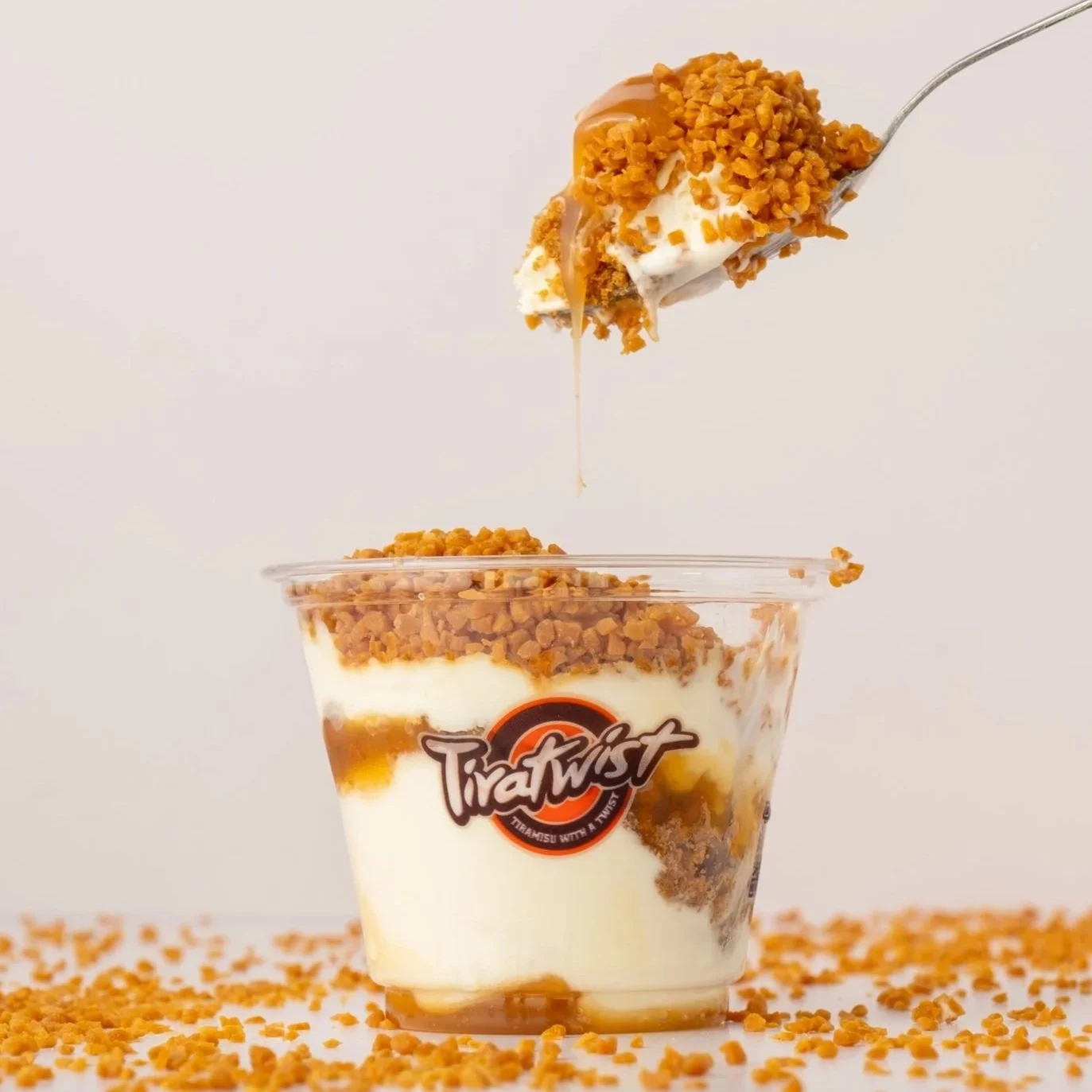 Layered dish in a glass jar with ground beef, white sauce, shredded cheese, and crushed red pepper flakes.