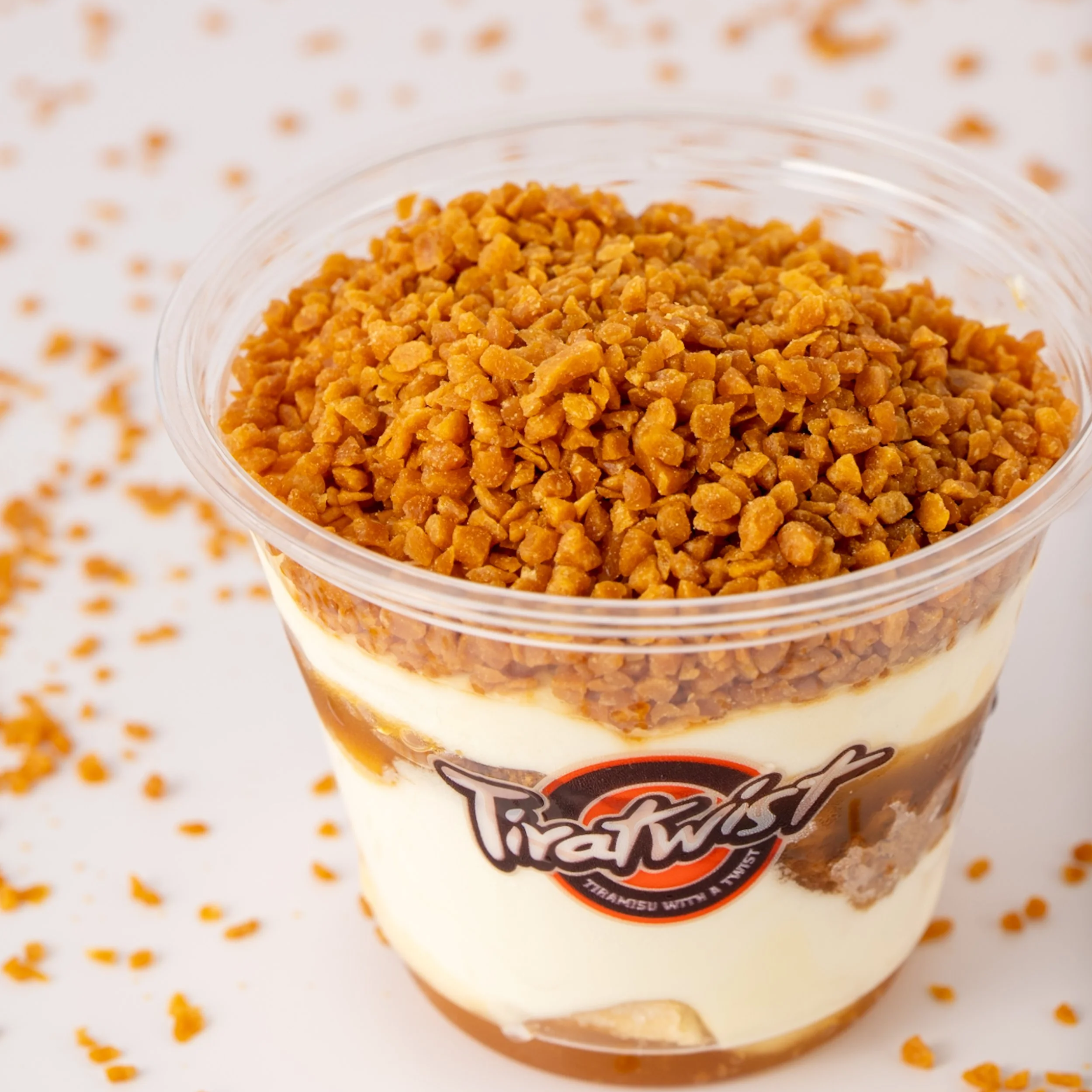 Close-up of a cup of tiramisu dessert with a crumb topping.