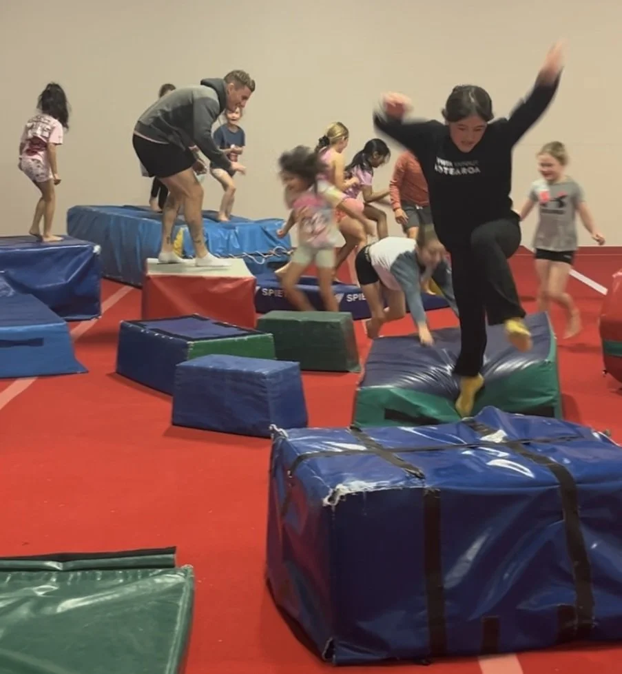 adults and kids playing on gym equipment
