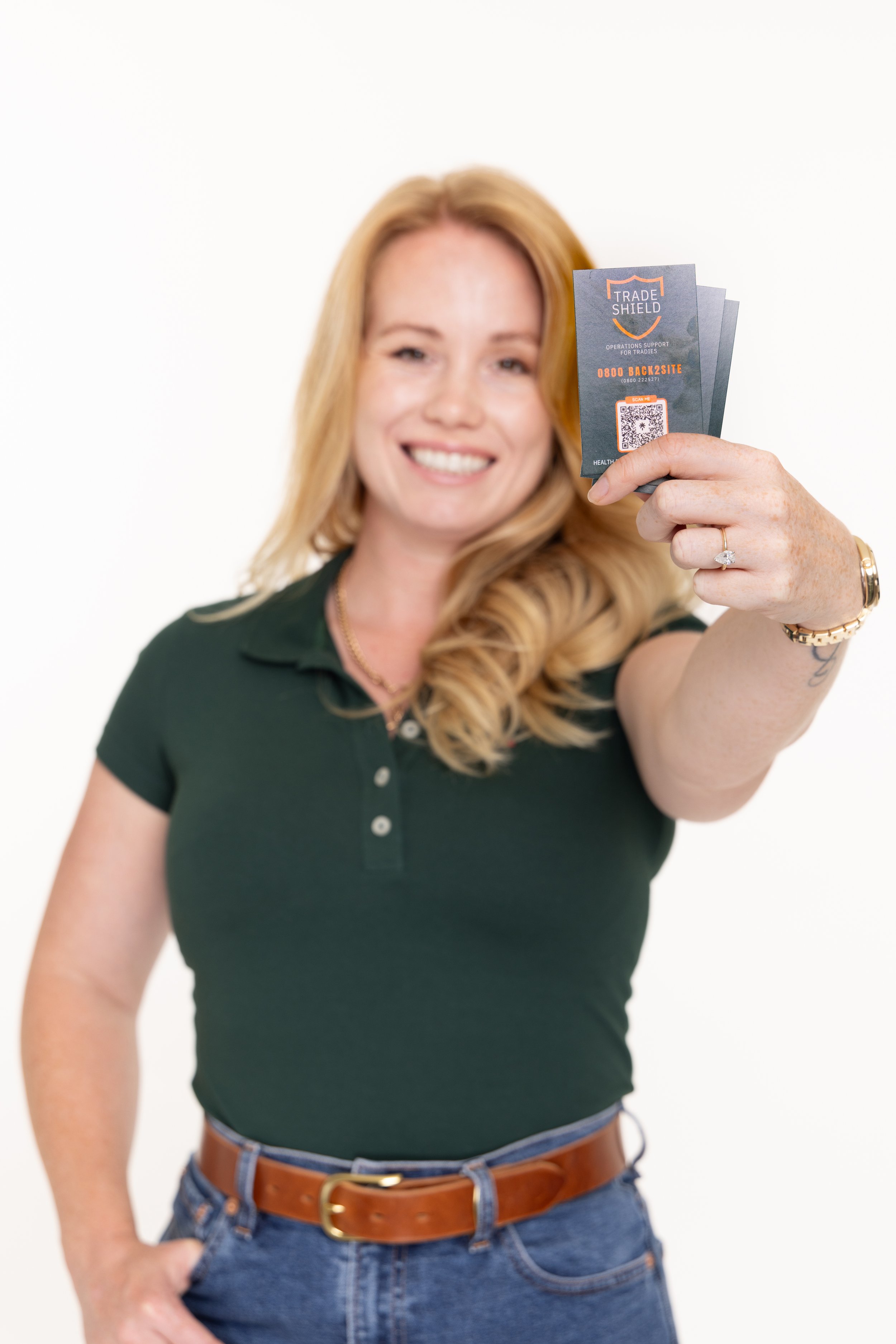 Chanel Jay posing for a photo holding business cards towards the camera.