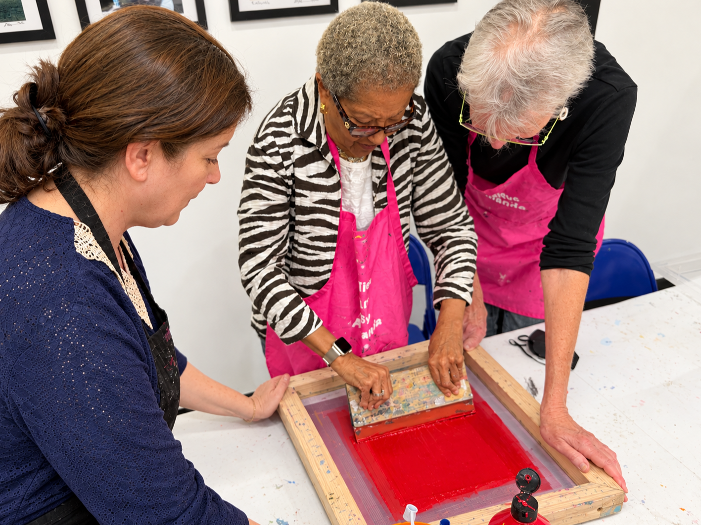 3 adults/ senior citizens helping each other creating Art
