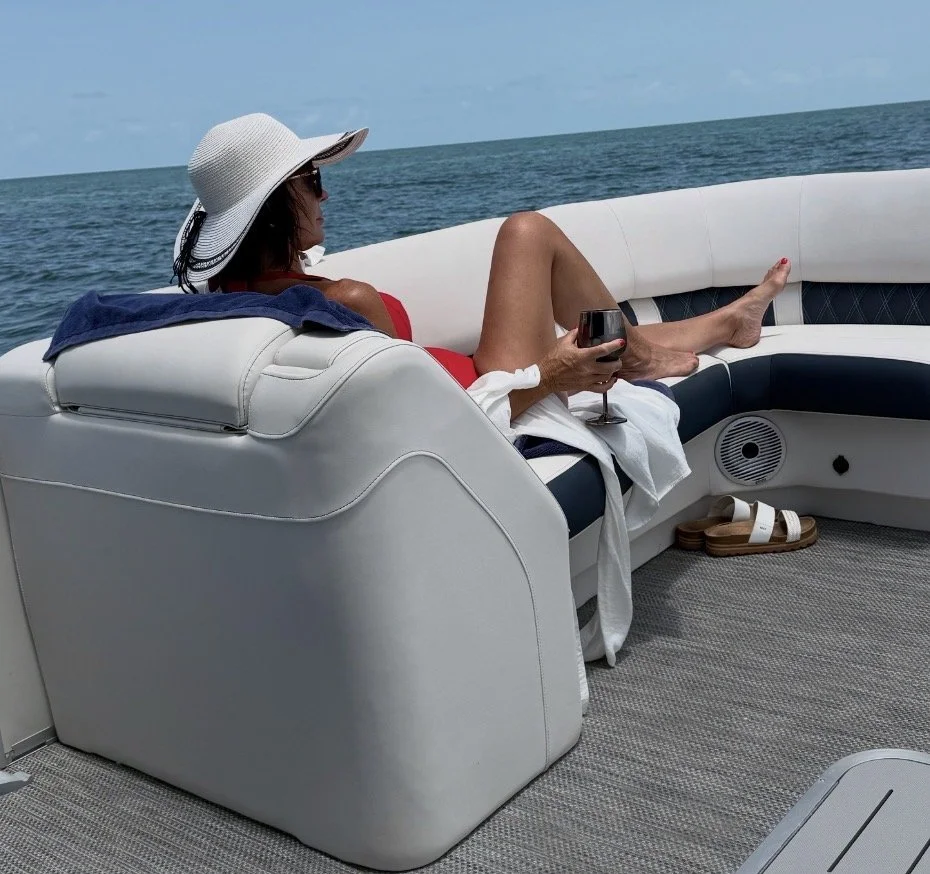 Kelly relaxing on a boat on a sunny summer day, enjoying a peaceful moment on the water as part of a balanced and meaningful life.