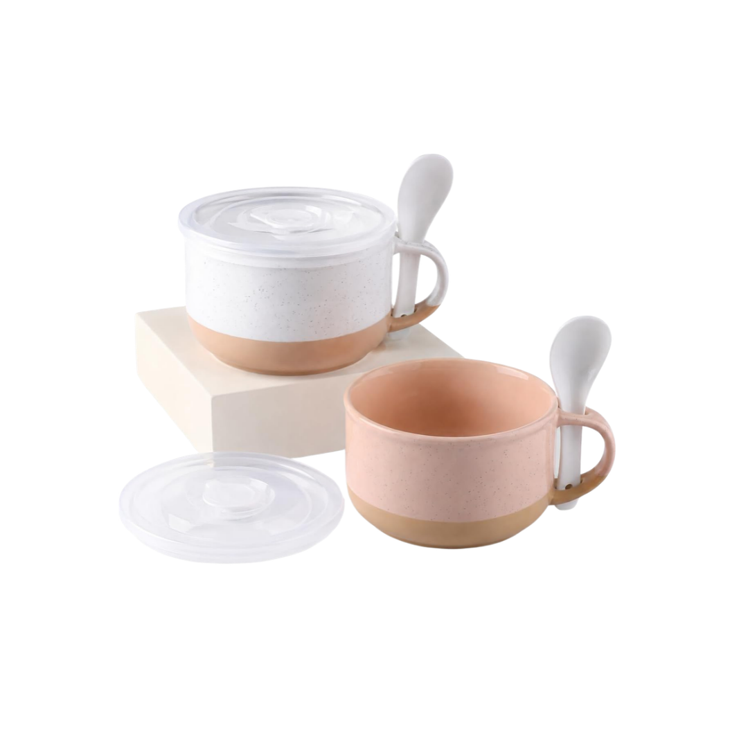 Two ceramic soup mugs in white and blush pink with natural-colored bases, matching lids, and white ceramic spoons.