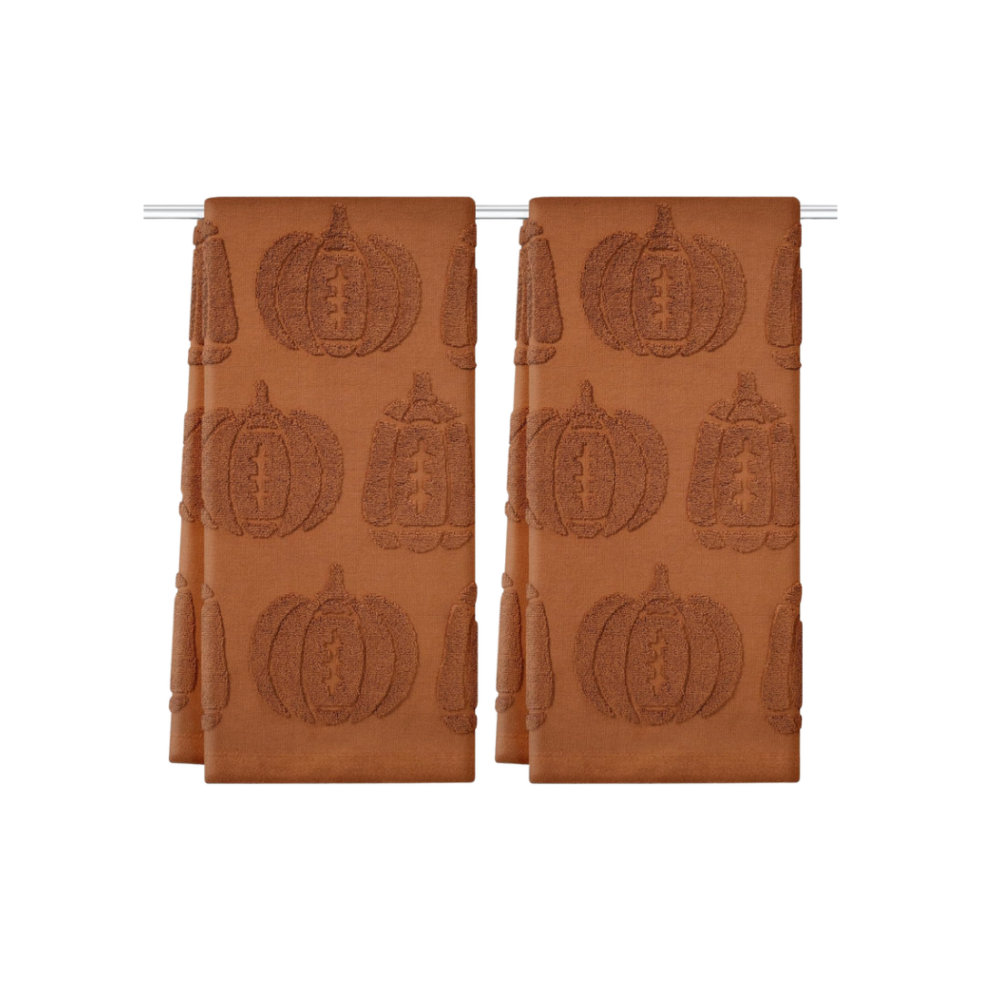 Two rust-orange hand towels featuring a textured pumpkin pattern, displayed on a towel bar against a white background.
