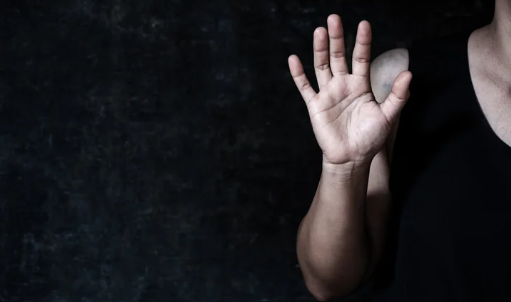 Family assault defense attorney in Texas hand raised in stop gesture symbolizing protection and legal defense.