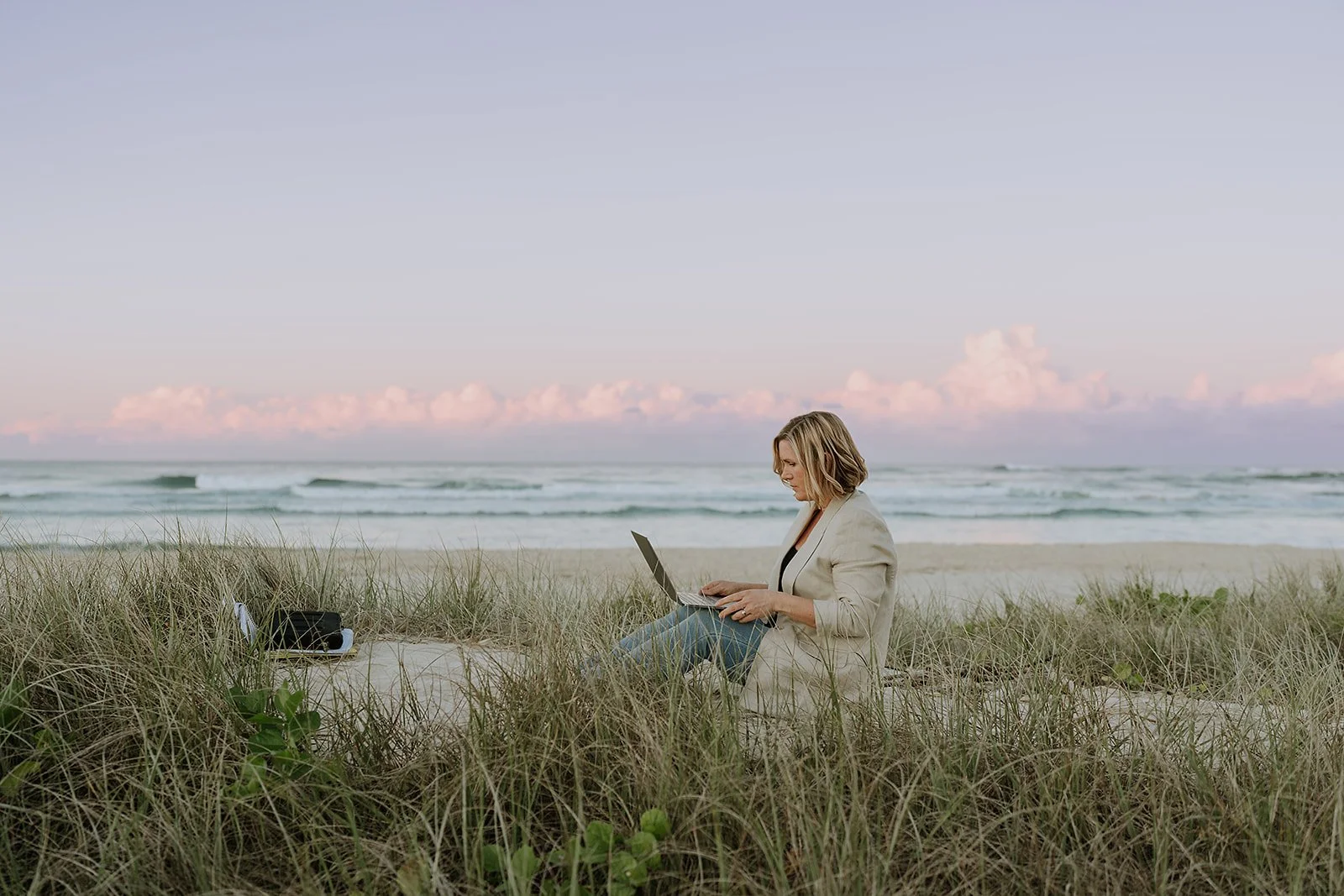 Abby Wallace copywriter working on the beach on a laptop