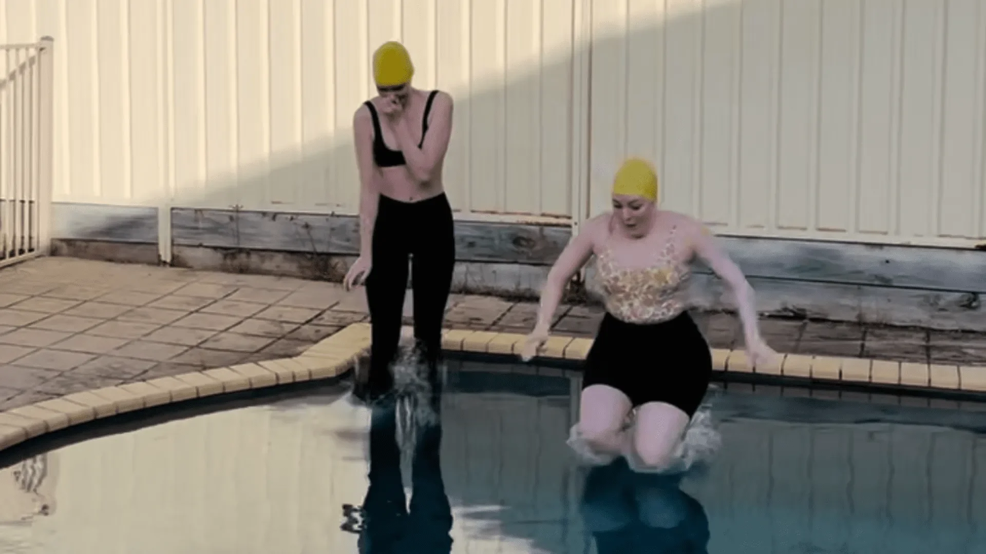 Two women jumping in the pool