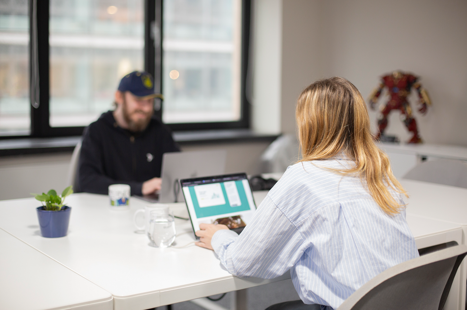 Deux personnes en réunion dans une salle de conférence avec des ordinateurs