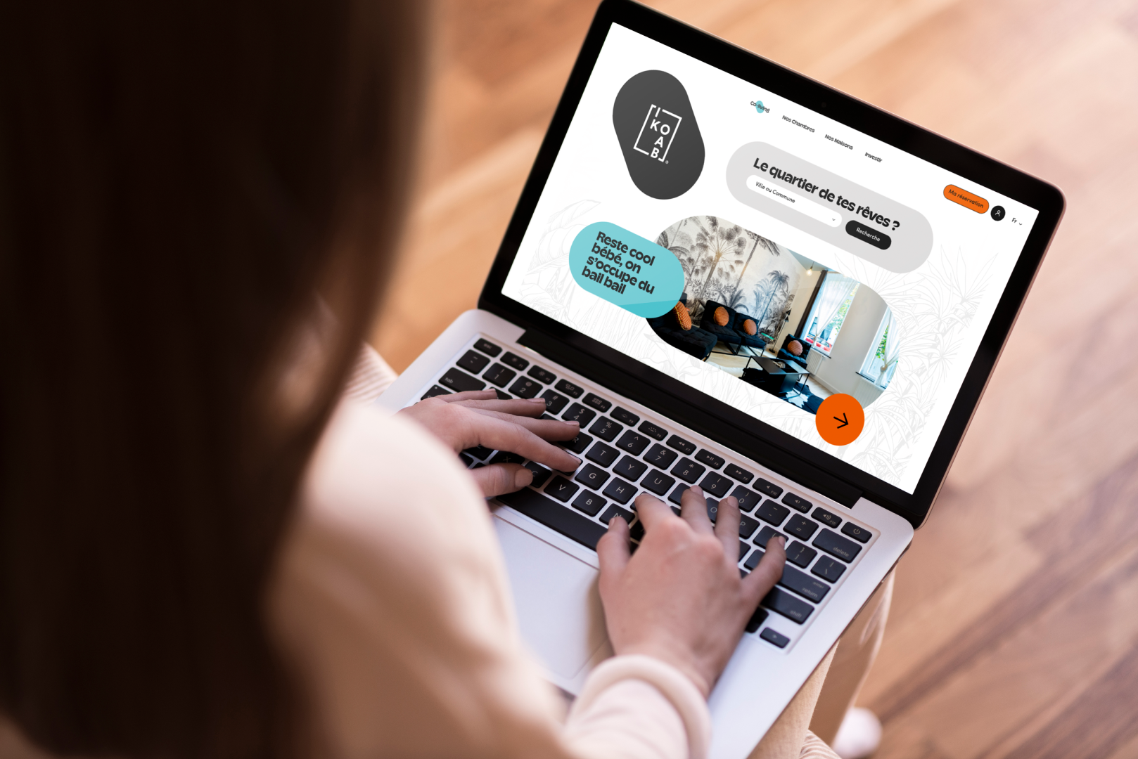 Capture d'écran d'un site web affiché sur un ordinateur portable, avec un design moderne, des couleurs vives, et un espace pour rechercher une ville ou une commune, représentant un projet immobilier ou communautaire.