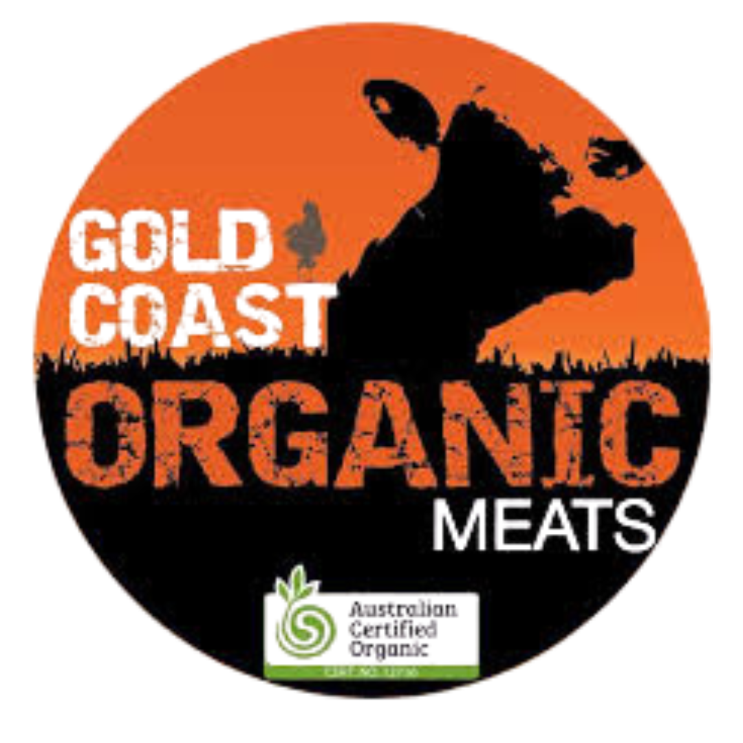 Black silhouette of a cow with a sunset in the background, the words 'Organic Meets' in distressed orange lettering, and a pineapple illustration at the bottom.