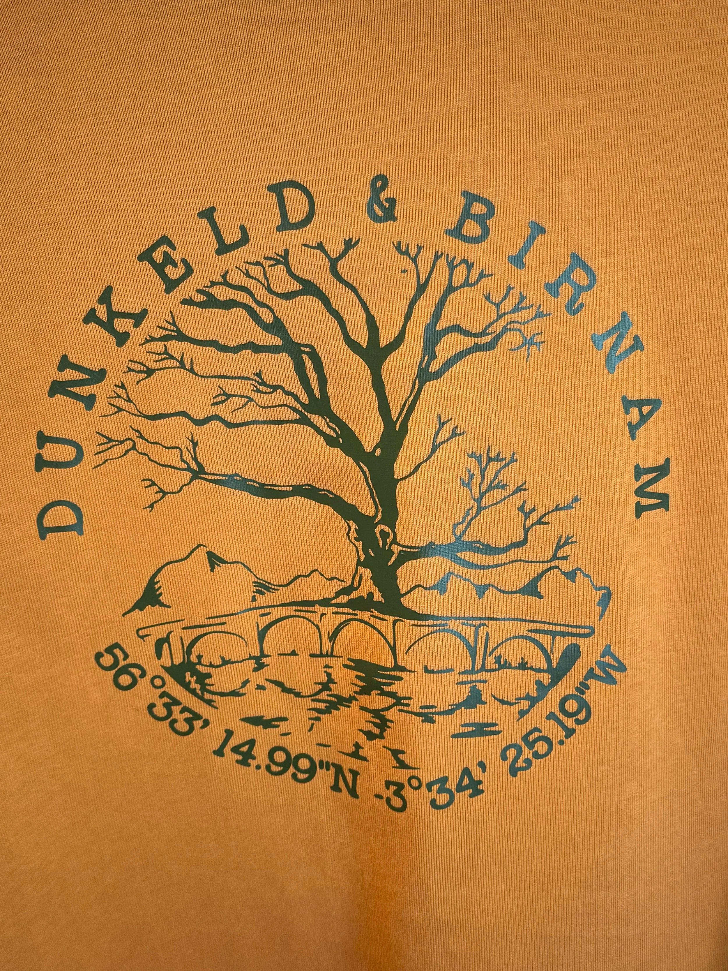 Design of a leafless tree on a hill with a bridge and mountains in the background, surrounded by the text 'Dunkeld & Birnam' and geographic coordinates.
