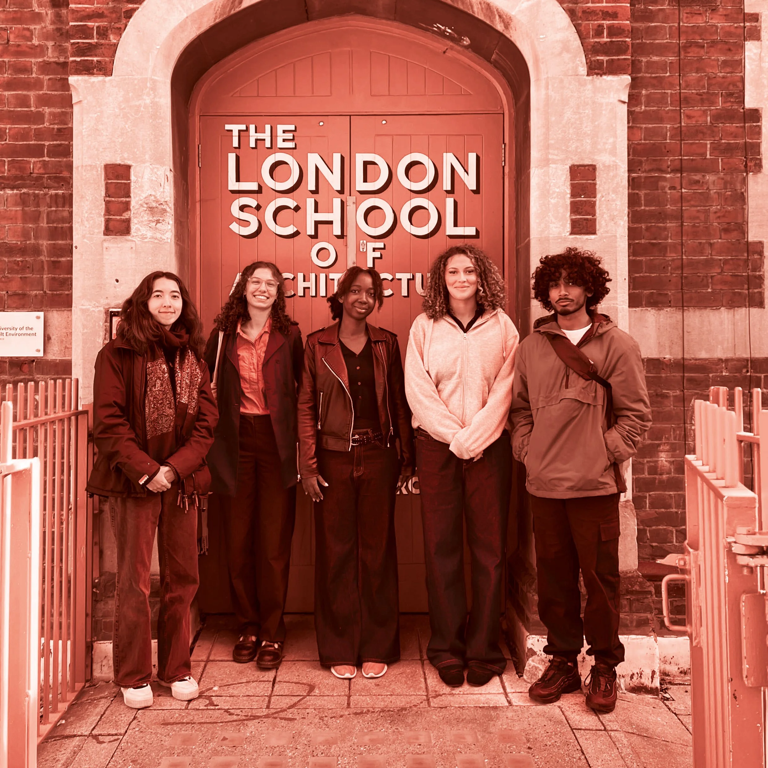 A group of five young people standing in front of a red door with a sign that reads 'The London School of Architecture'. They are smiling and appear to be students.
