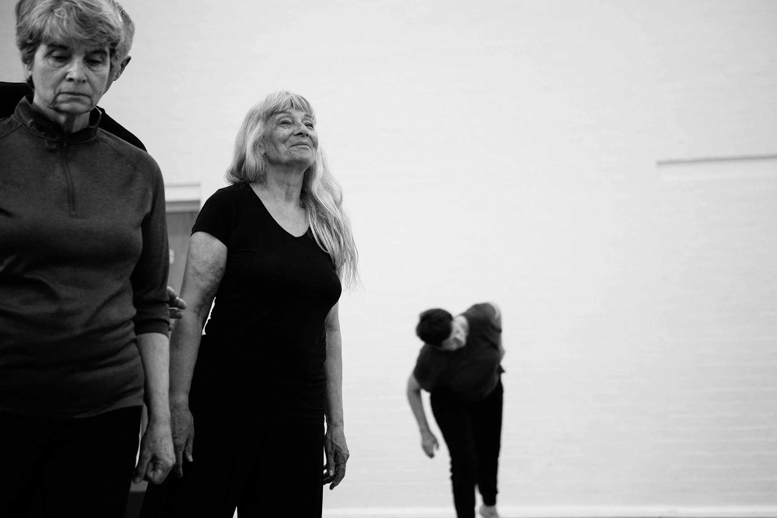 A group of older with main focus on a dancer smiling.