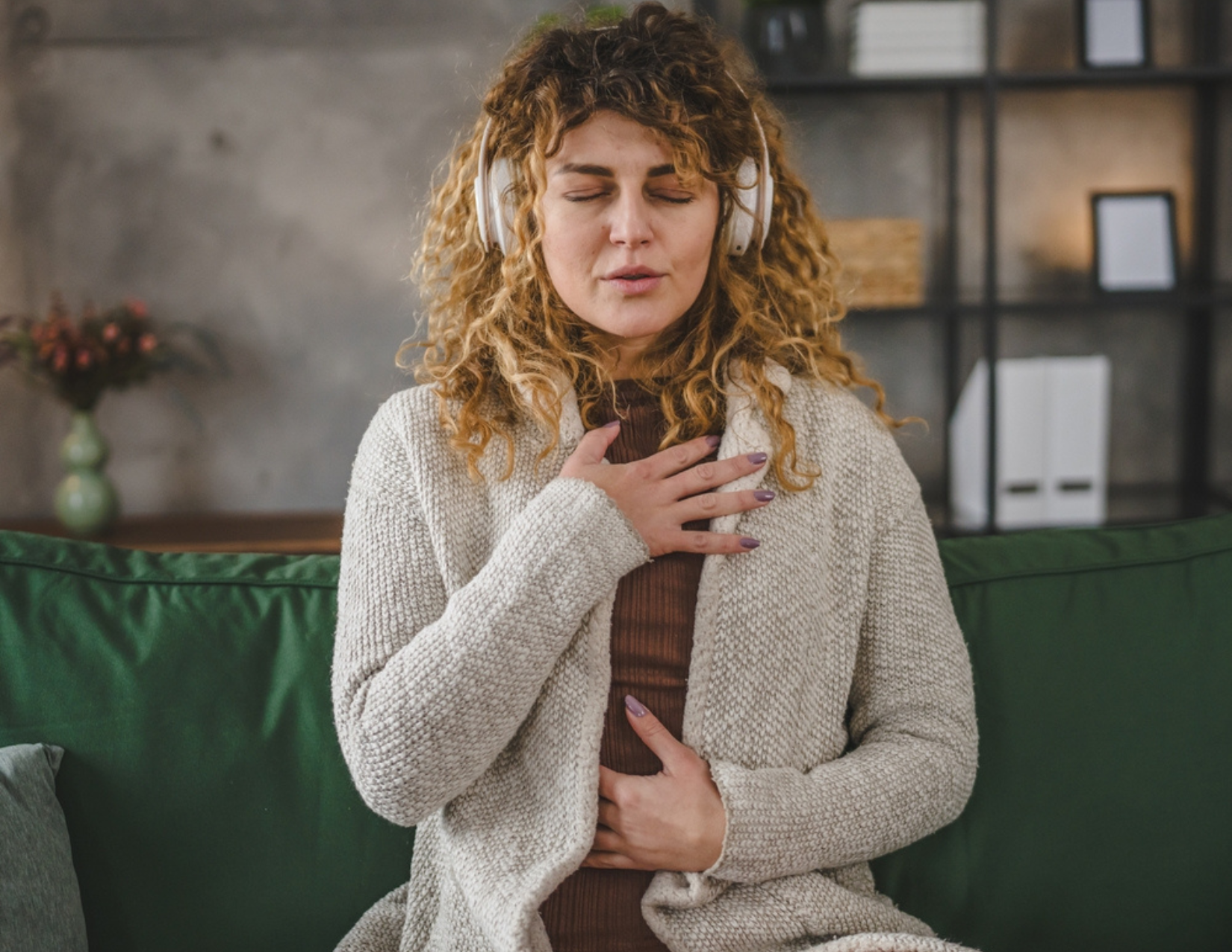 girl with headphones with hand to chest and stomach