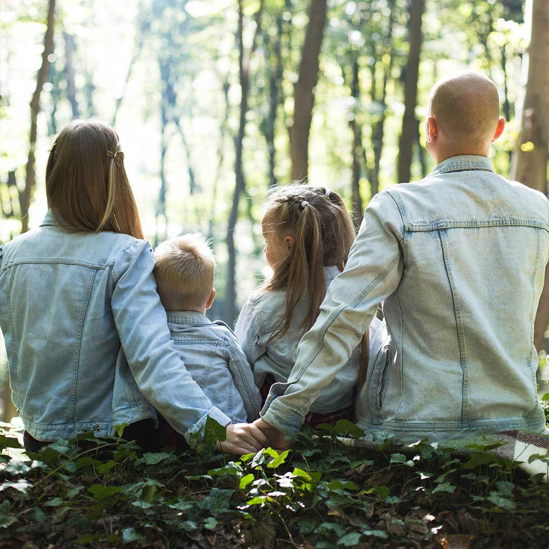 family sitting down with 2 young children in middle
