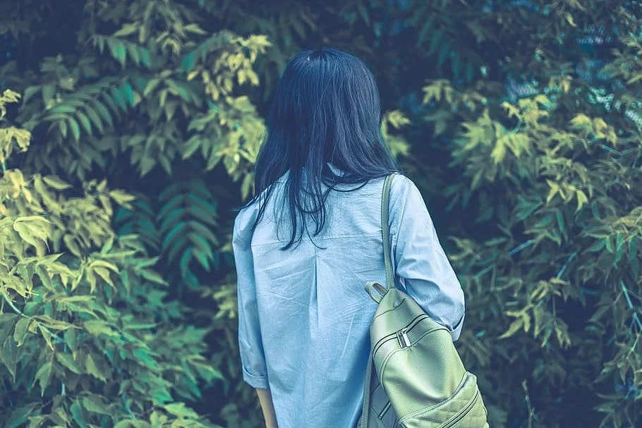 girls back with blue shirt and green backpack