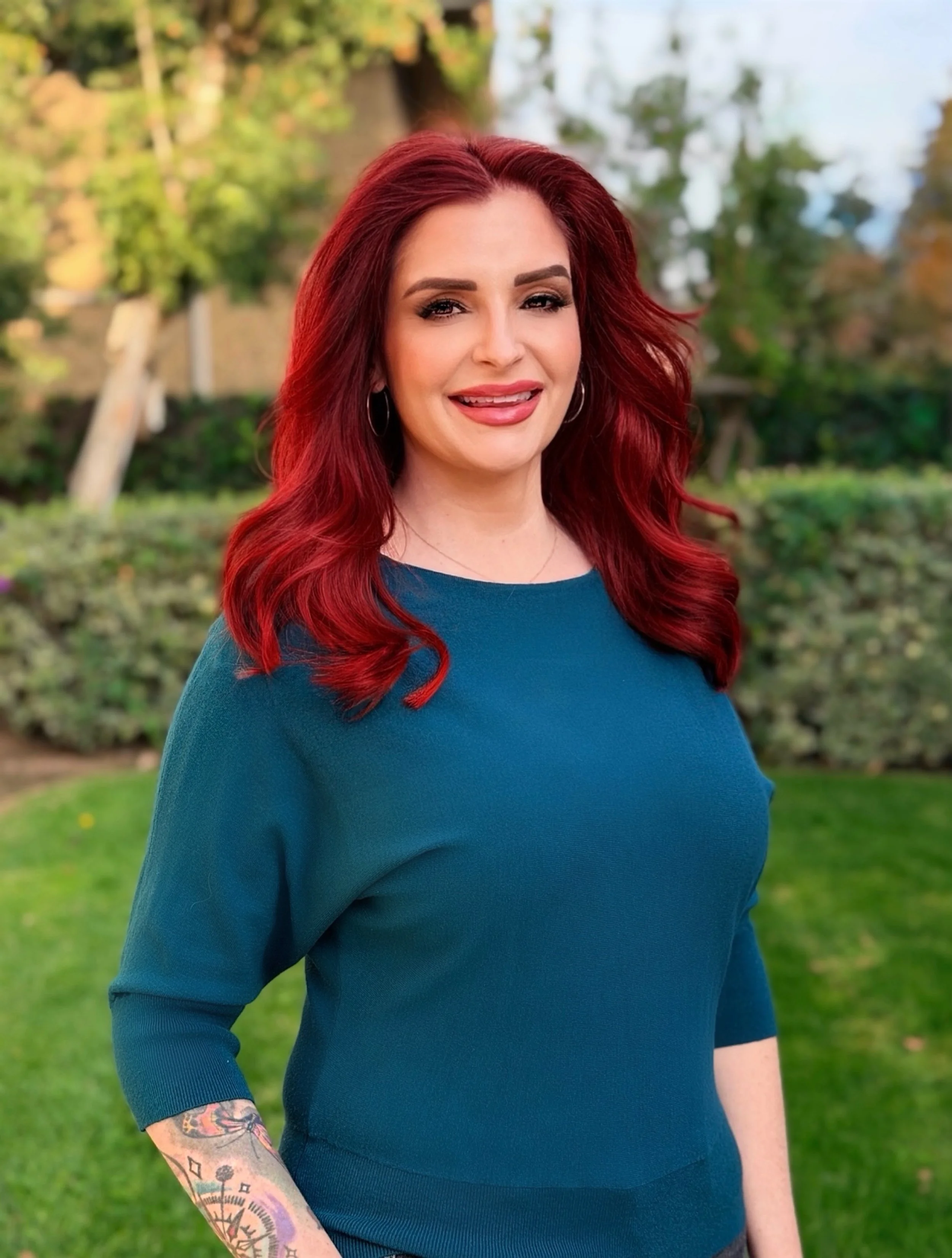 Woman with red hair and teal shirt