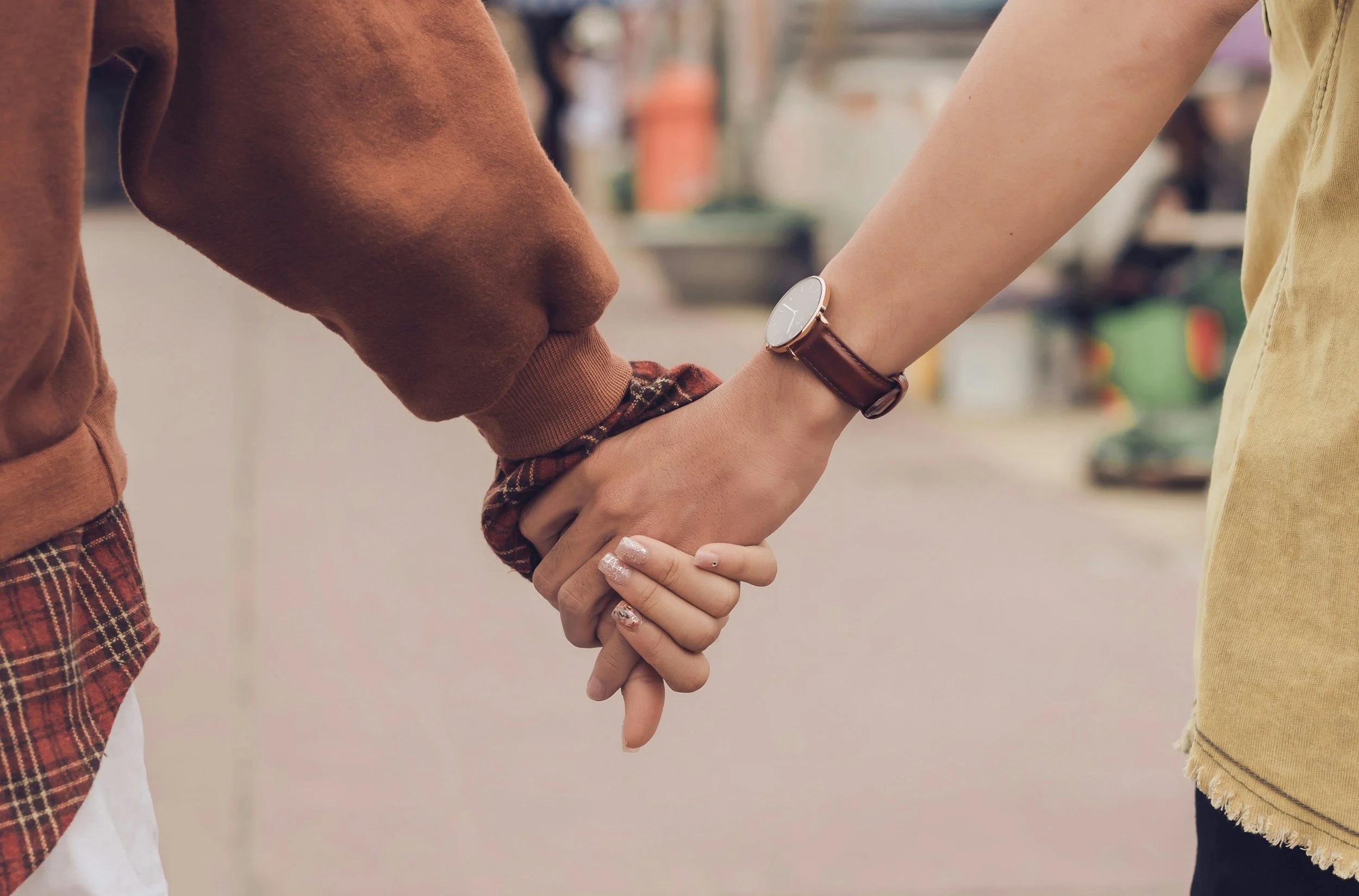 Two adults holding hands, reflecting emotional safety and the possibility of secure, connected relationships.