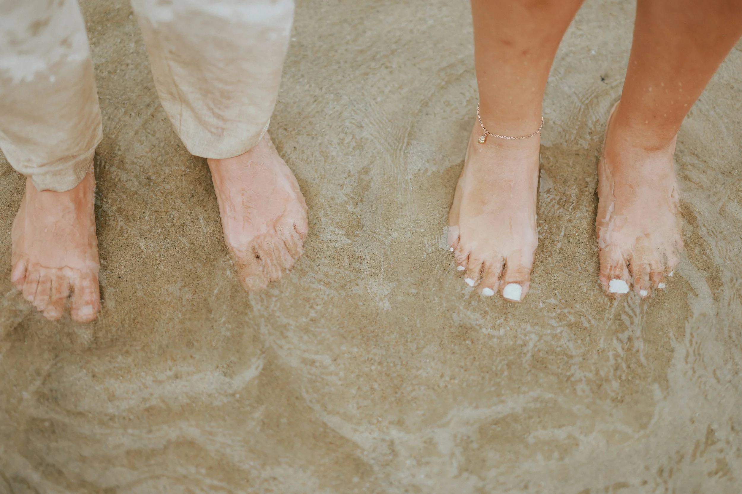 Bare feet in water, symbolizing slowing down, presence, and reconnecting with yourself.