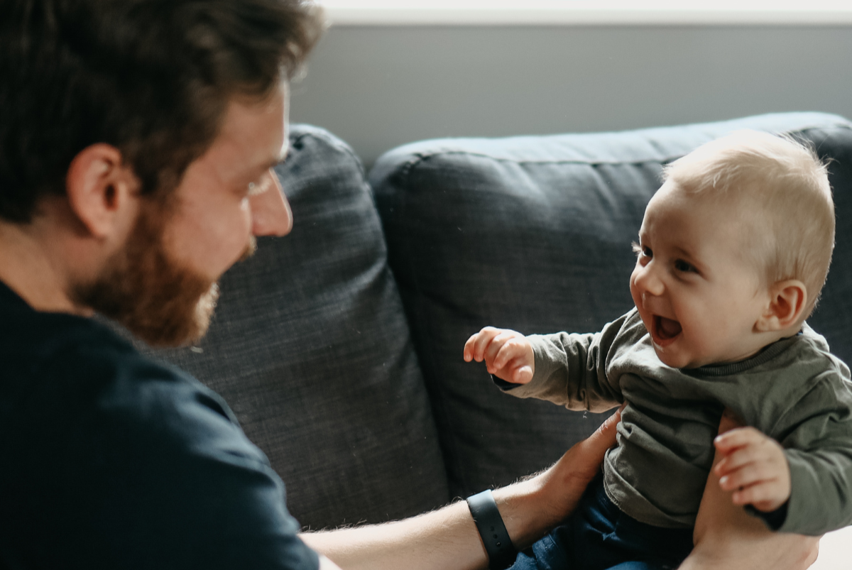 Parent gently holding and looking at child with warmth and connection, representing the early roots of attachment.