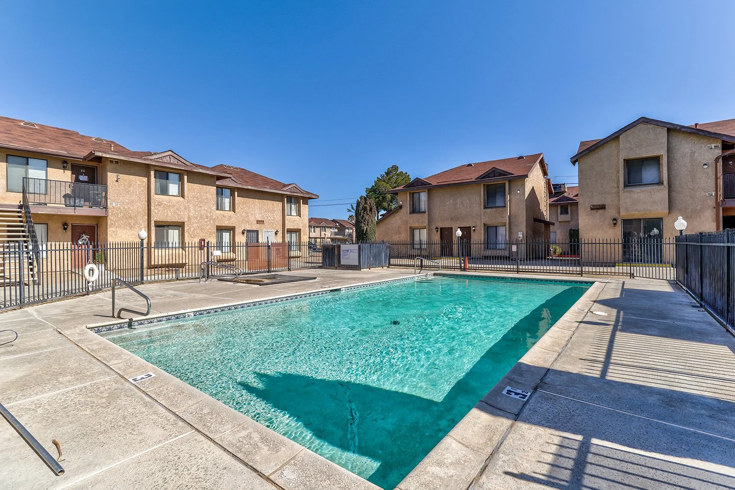This image showcases a large, shimmering pool enclosed in a safety fence. 