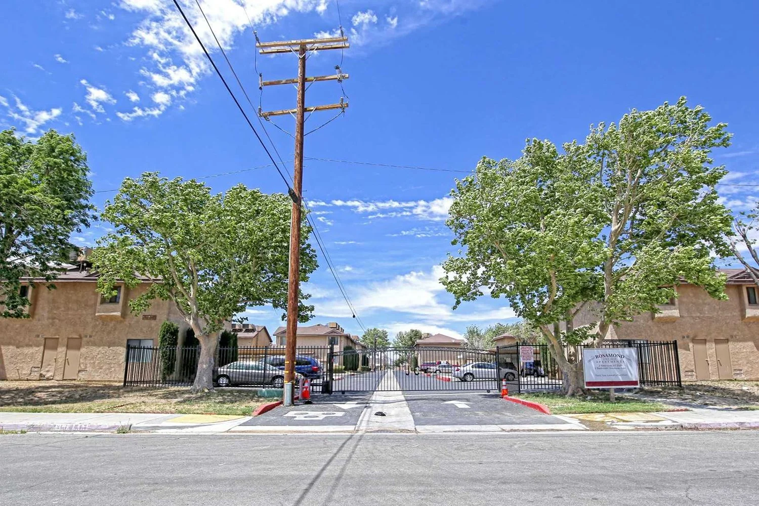 This image includes the street-view of the apartment complex that is gated. 