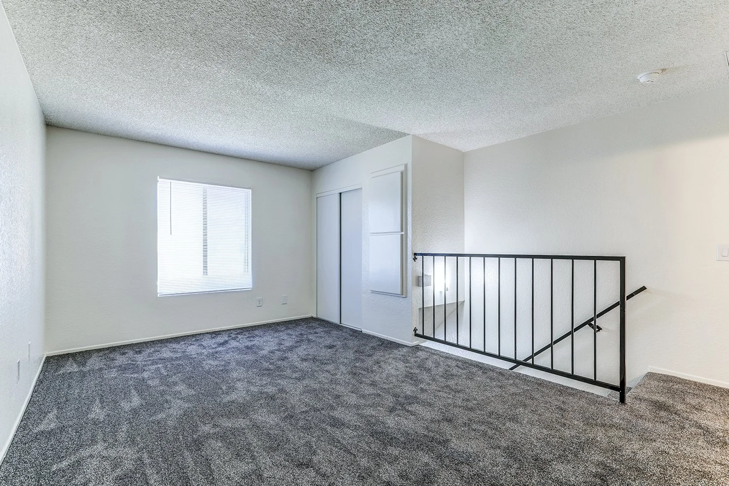 This image shows the upstairs of the apartment, featuring a large window and a sliding-door closet. 