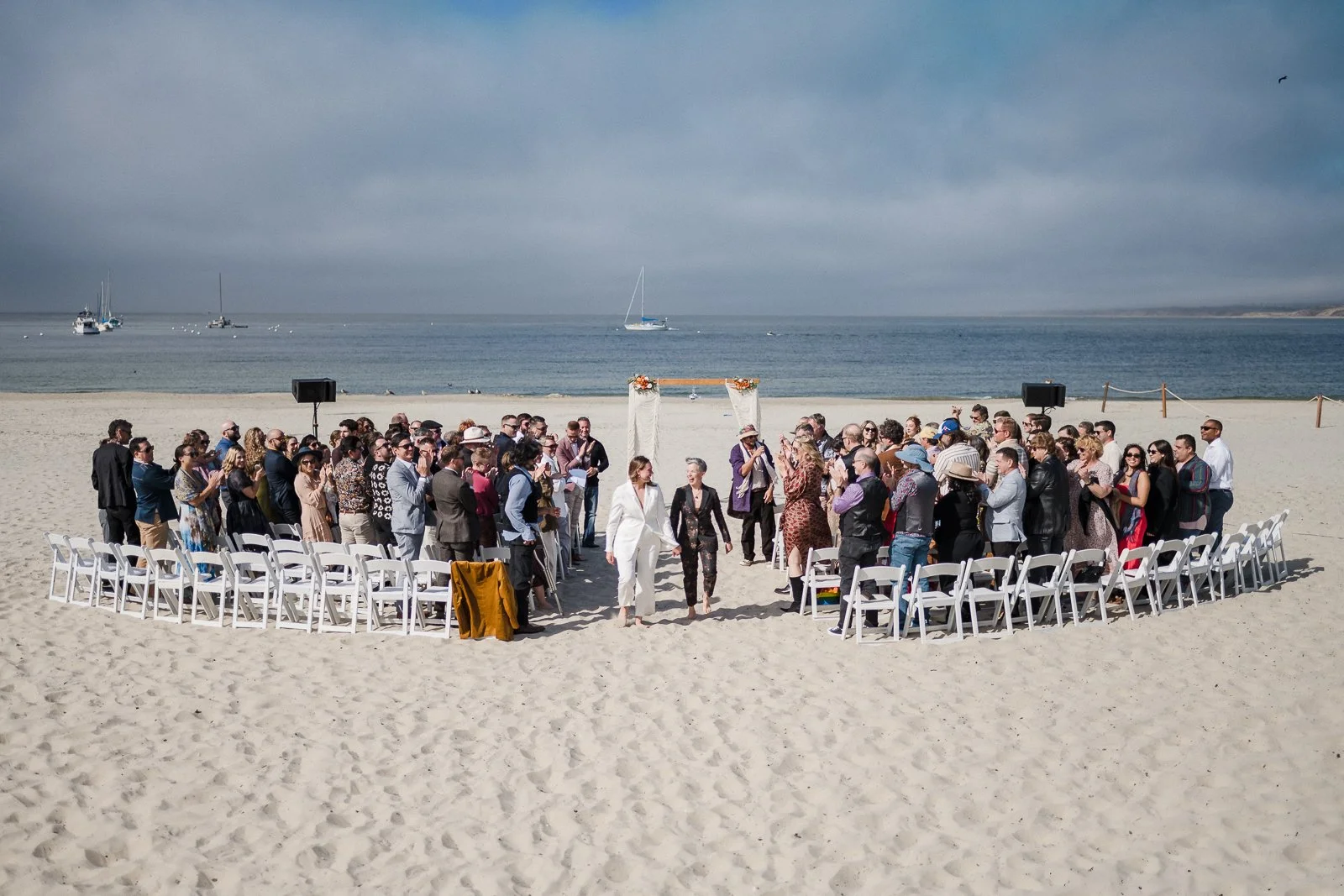 A large wedding party on a beach. Photo by Tatiana Scher Photography.