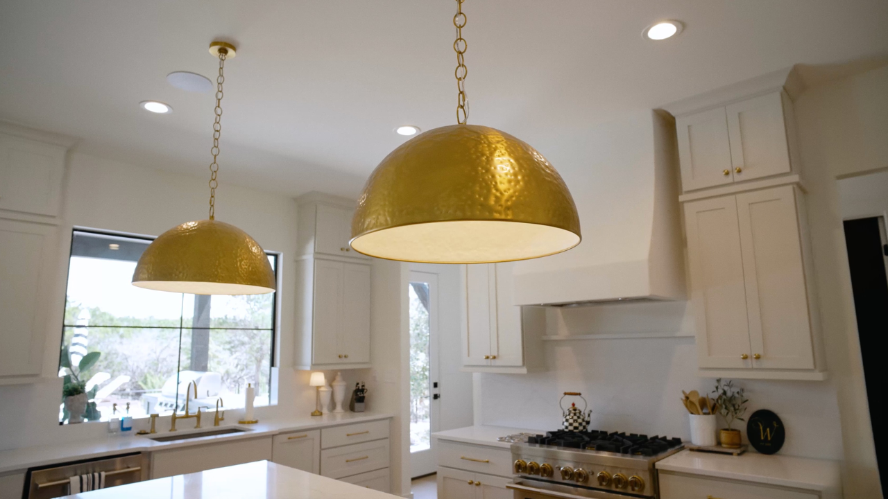 Kitchen with hammered brass pendants by custom home builders in Texas Hill Country, with Texas Living Homes in Fredericksburg, Texas and the Texas Hill Country