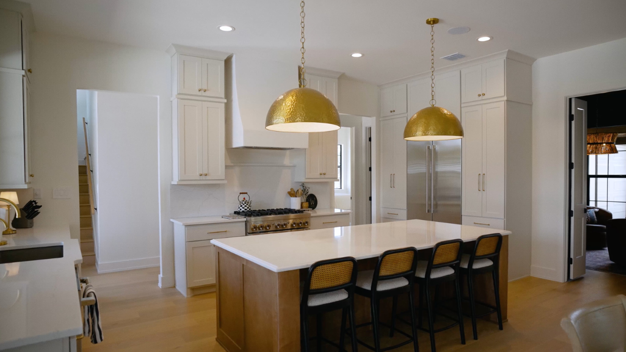 Kitchen island with brass pendants and seating in custom homes, Texas, with Texas Living Homes in Fredericksburg, Texas and the Texas Hill Country