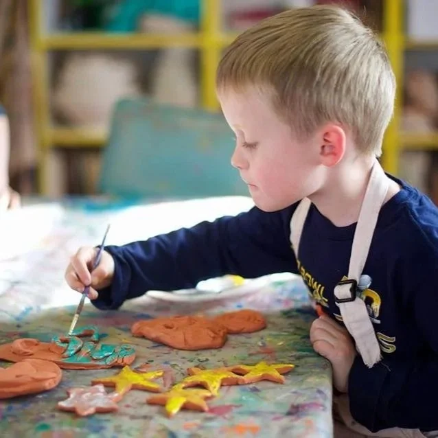 Young Boy Painting Pottery