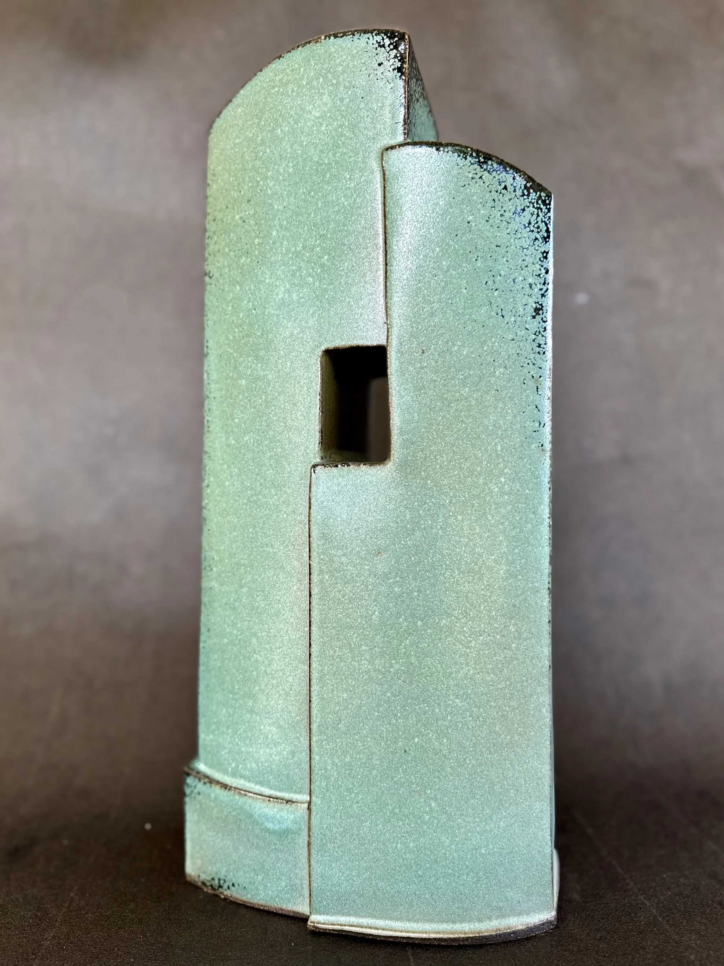 Teal abstract ceramic sculpture with a rectangular cutout by ceramic artist, Bebe Alexander