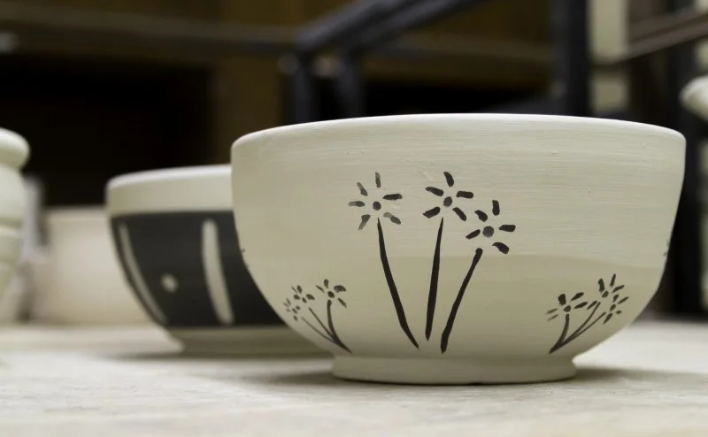 Two ceramic bowls with black and white underglaze designs. Made in the Level II Throw Down Wheel class at Groundworks Art Lab in Boulder, CO.