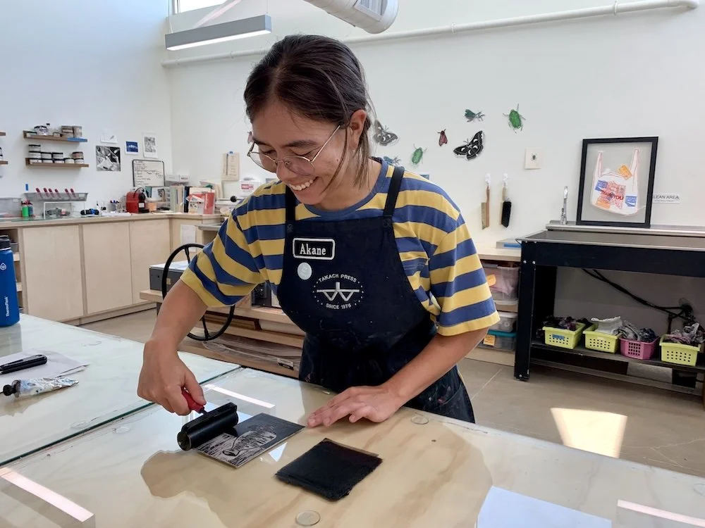 akane rolls ink onto print block in print studio