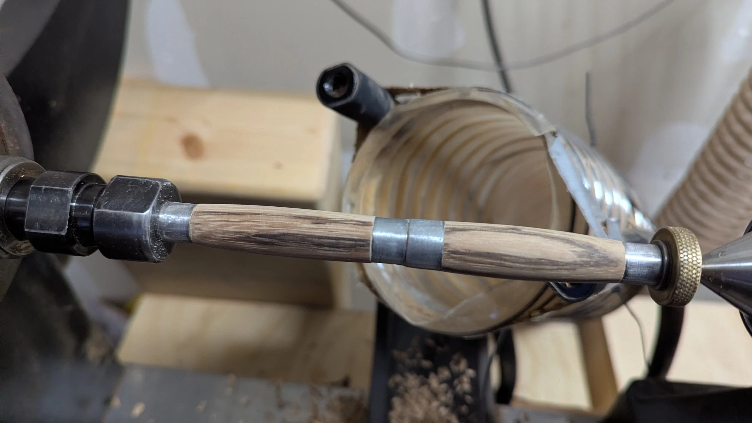 A woodturned wooden pen still attached to the lathe. Groundworks Art Lab in Boulder, CO now teaches pen turning.