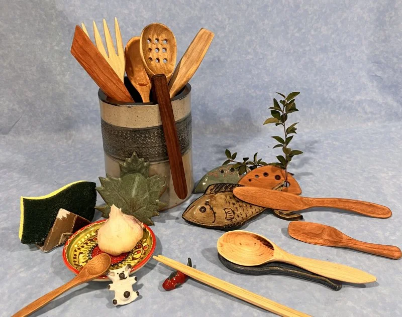 An assortment of handmade ceramic and wooden kitchen items and utensils