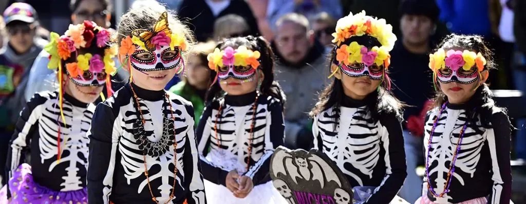 children in dia de muertos costumes, masks and color head pieces.