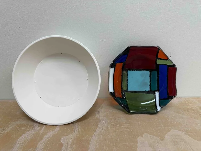 A wheel-thrown ceramic bowl mold next to the multi-color fused glass bowl that was slumped in it. Made in the Bisqued Molds & Glass Bowls crossover class at Groundworks Art Lab in Boulder, CO.