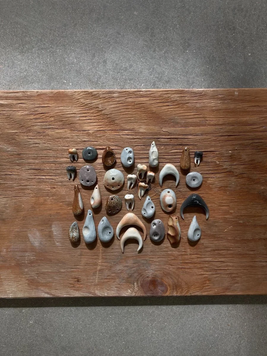 A collection of hand-built clay pendants that have been soda fired at Groundworks Art Lab in Boulder, CO