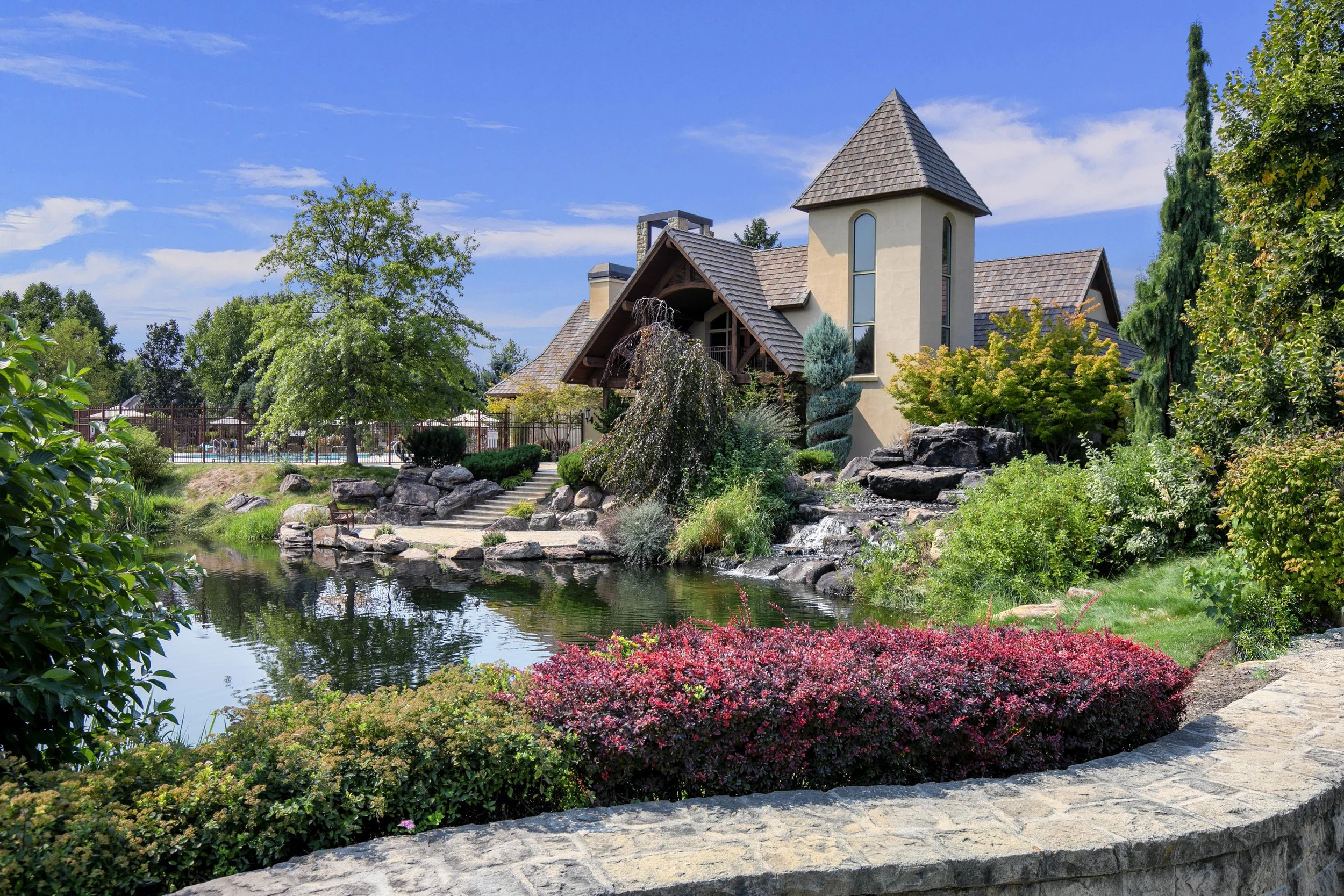 Clubhouse, pond, and waterfall surrounded by mature landscaping in the Two Rivers community in Eagle, Idaho
