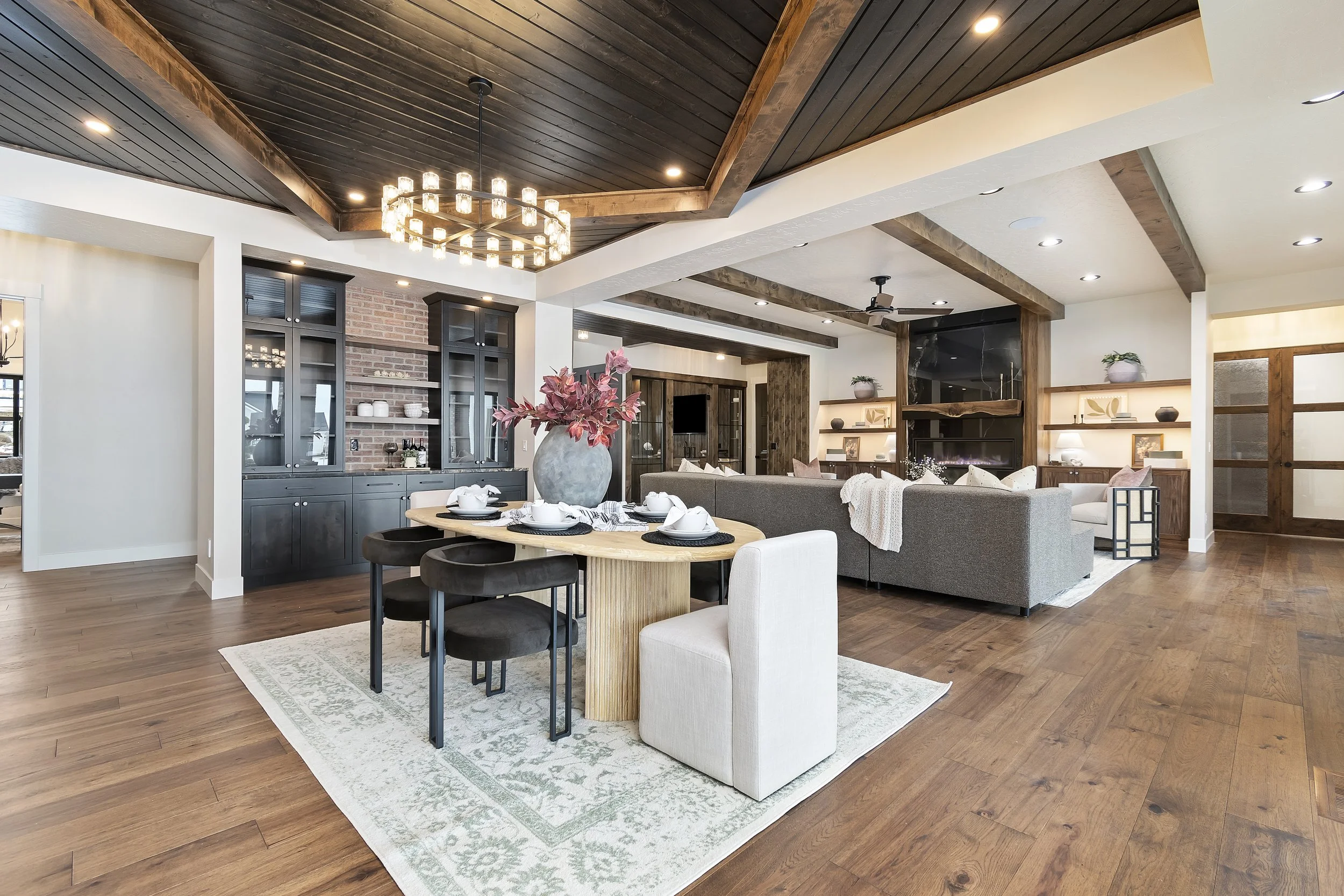 Dining room in The Lucas by Bachman Custom Homes, a luxury home in Eagle, Idaho, with a round wood table and statement chandelier