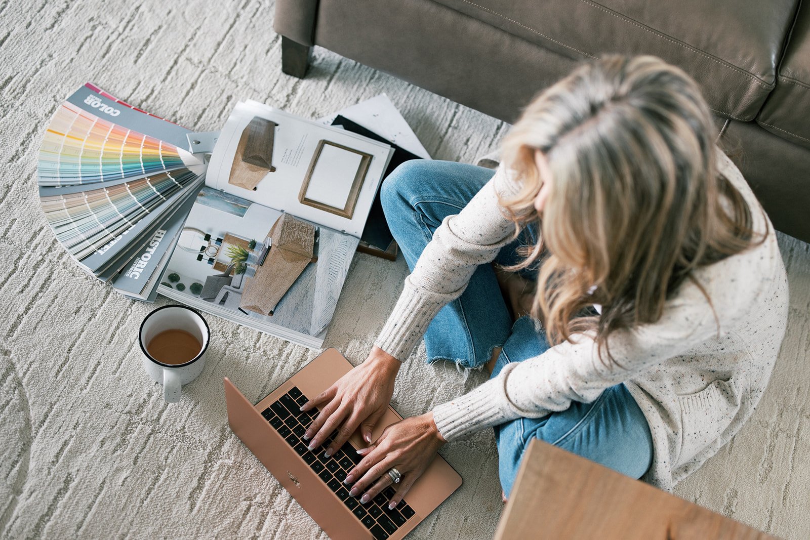 Realtor Rachel Postigo reviewing paint swatches and design magazines on a laptop