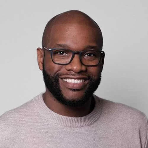 Headshot of Male corporate professional in Stamford CT wearing glasses, a sweat shirt and in front a a light gray backdrop
