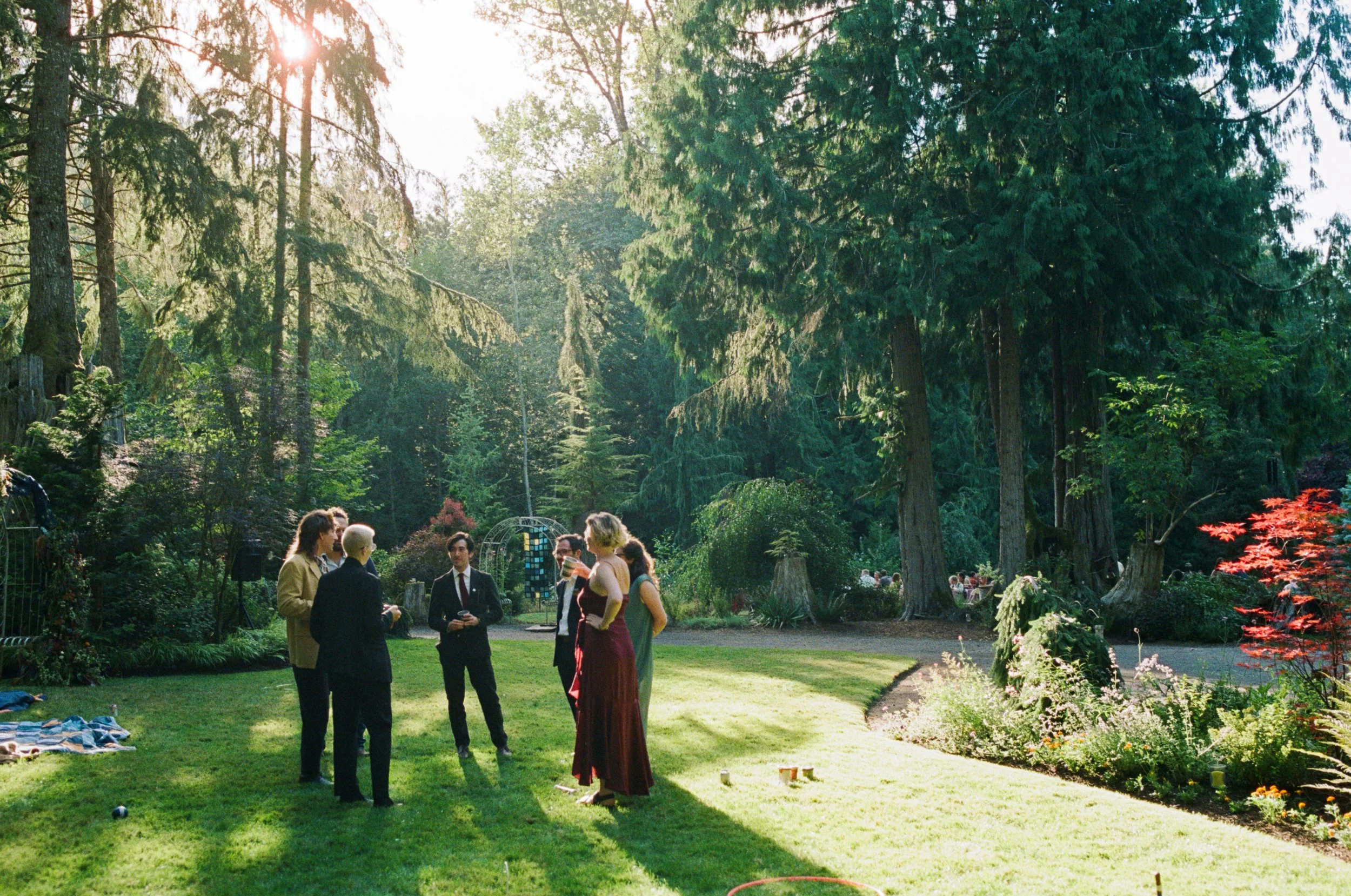 People stand around in nice outfits after an outdoor wedding in Seattle, WA. Photographed by outdoor wedding photographer Holly Stevens.