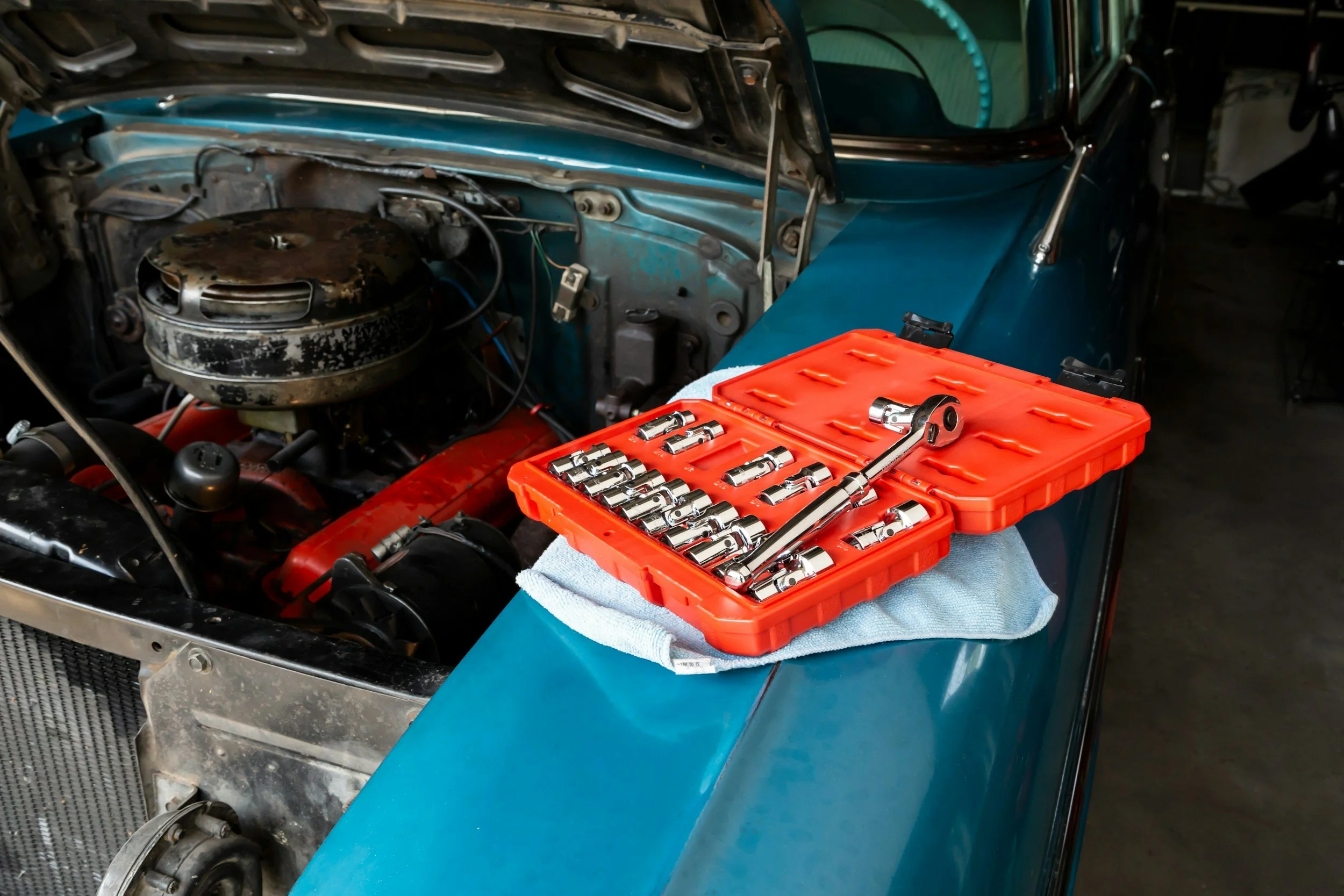 car inspection, blue car with open hood some tools laying on the side
