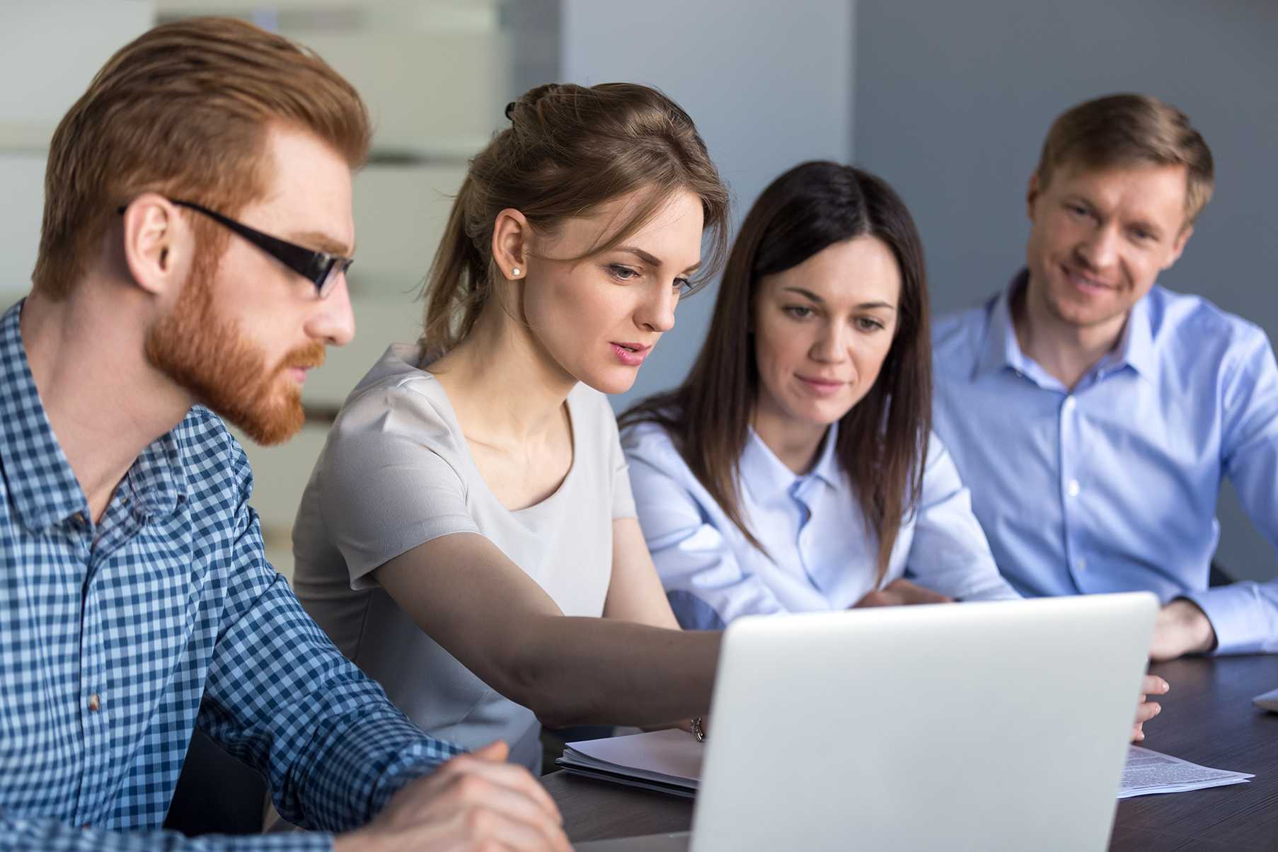 Four teachers gather around a computer
