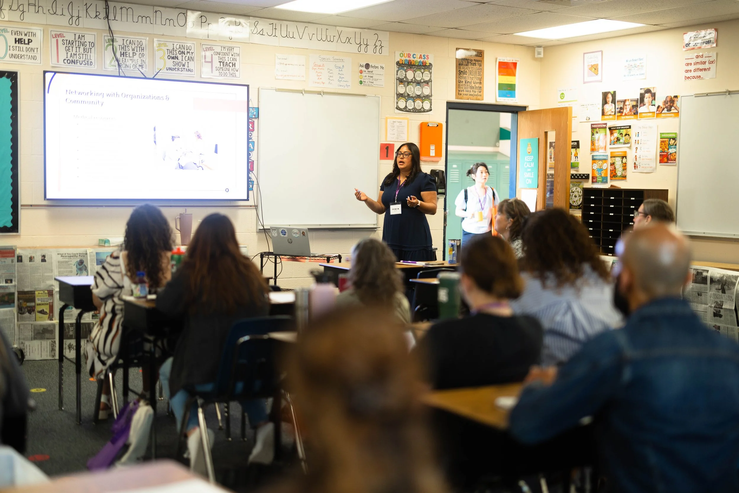 Presenter talking to a group of conference attendees in a classroom